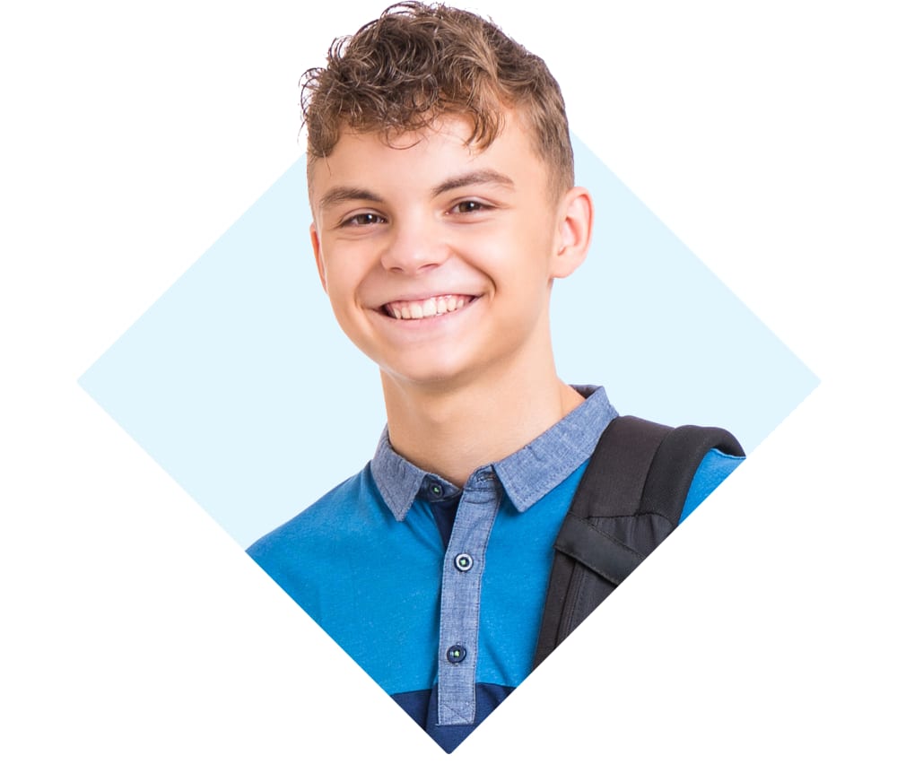 A teenage boy is smiling and wearing a backpack.